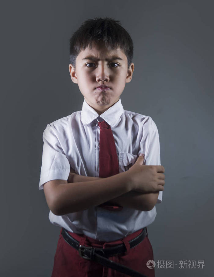 年轻男孩7或8岁在学校制服感觉心烦和愤怒看不开心和