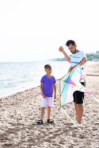 父亲和他的儿子与风筝在海附近