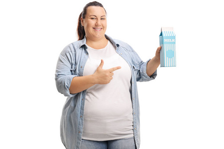 超重妇女拿着牛奶纸盒和指向被隔绝在白色背景