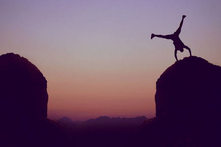 运动体操运动员在山作为标志为乐趣户外在日落