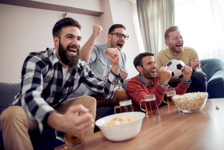 友谊, 体育和娱乐快乐的男性朋友看体育在家中