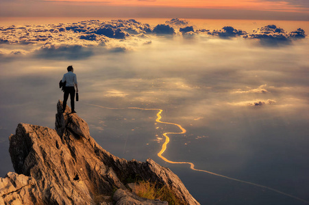 年轻生意人穿着舒适休闲西装夹克站立在山顶山顶和前瞻, 成功, 竞争