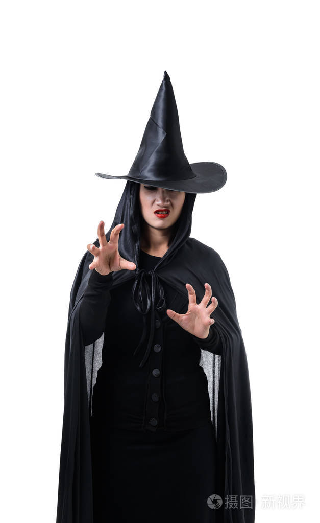 照片 在黑色可怕的女巫万圣节服装的肖像站在白色背景的帽子和喃喃的