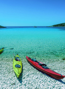 黄色和红色海独木舟在海滩以蓝天和海背景在科纳提海岛的海湾, 国家公园在克罗地亚, 亚得里亚海, 在希贝尼克, Croati