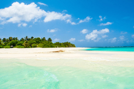 美丽的海滨沙滩日光浴浴床与撑着雨伞，印度洋马尔代夫岛