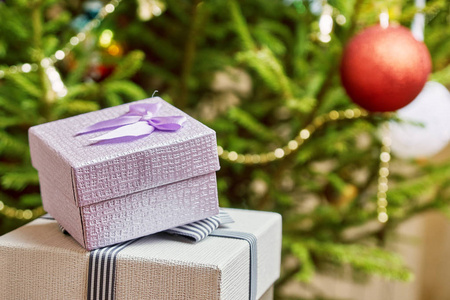 新年前夜在家里的圣诞树下的盖子上有蝴蝶结的礼品盒