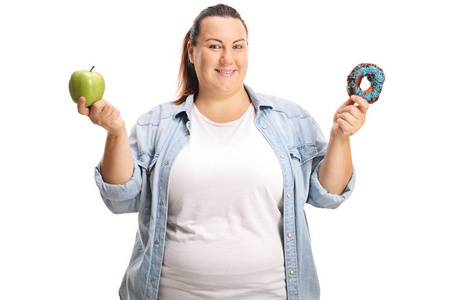 超重妇女拿着一个苹果和一个甜甜圈在白色背景下隔离