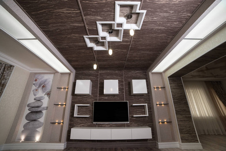 带白色沙发和大等离子电视的实木复合地板照明灯具在深色木墙上的现代设计