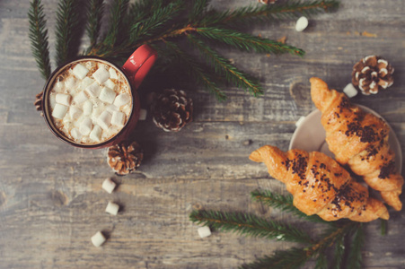 棉花糖和羊角面包与圣诞灯仿古木制的桌子上的热可可。舒适的冬天的家居理念