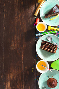 查看儿童生日表的概念。巧克力蛋糕和装饰党在褐色木质背景与拷贝空间平的放置