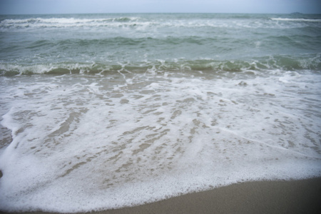 海泡沫软波在沙滩上的选择性焦点