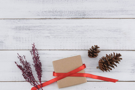 棕色礼品盒, 松果和紫色干花花束在白色的木材背景, 选择性聚焦棕色礼品盒