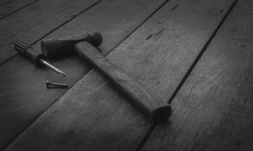 老木桌上的旧锈锤螺丝刀和钉子。修理和修理家庭用的木工工具。旧工作台上的木工工具。Diy 工具套件。房屋施工设备。家居修复