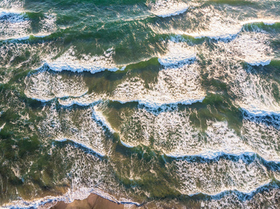 空中的波浪在海洋中与温暖的日落光的看法。顶部视图