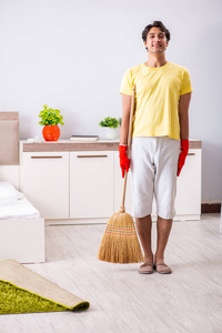 年轻英俊的人在卧室里打扫卫生