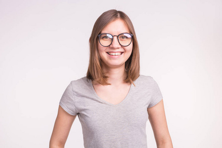 时尚与人的概念在白色背景下戴眼镜的年轻笑脸女郎的肖像复制空间