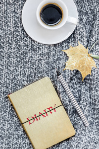 创意秋季平躺顶部景观时尚家居工作区与笔记本咖啡杯舒适灰色针织格子背景复制空间。女性博客社交媒体秋季季模板