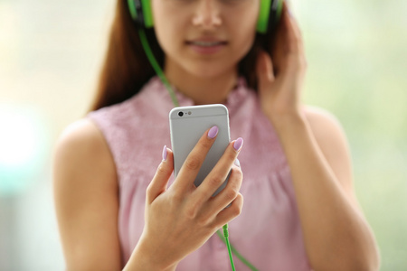 女孩听音乐耳机与智能手机
