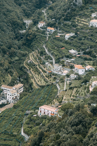 阿马尔菲海岸和山坡上有柠檬种植园。全景的城市和意大利的性质。傍晚的风景和蜿蜒的道路。天空在海和岩石