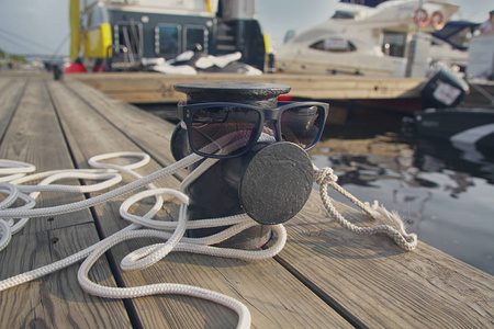 码头和太阳镜上的系缆绳。生活方式。游艇俱乐部