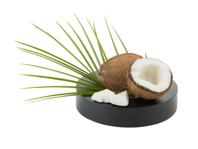 在白色背景下分离的一半和整个椰子的特写图片。富含维生素的叶子的异国水果概念