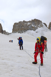 一群登山运动员沿着冰川行走。文芳帕米尔 Alay塔吉克斯坦的户外山肖像