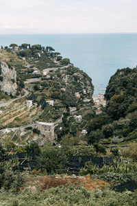 阿马尔菲海岸和山坡上有柠檬种植园。全景的城市和意大利的性质。傍晚的风景和蜿蜒的道路。天空在海和岩石