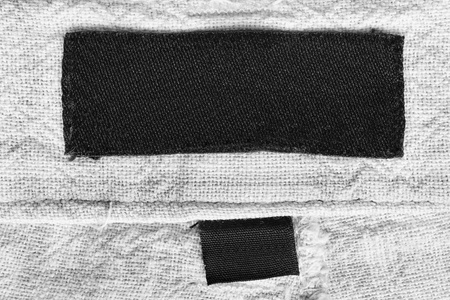 空白的黑色衣服标签上纺织品白色背景特写