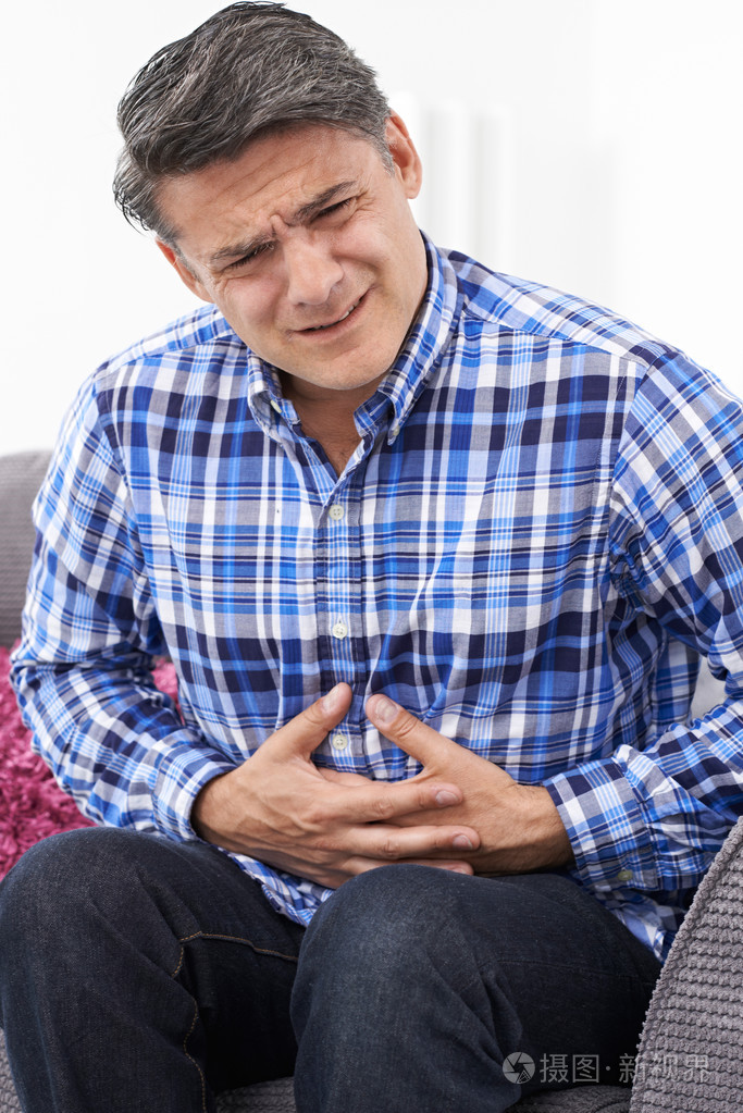 成熟的男人患有胃疼在家里