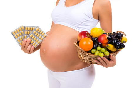 健康怀孕 丸或水果吗特写镜头的怀孕的肚子