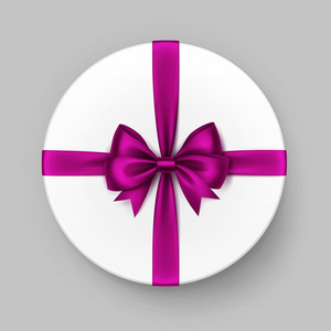 白色的圆圆的礼品盒用粉红色紫色缎蝴蝶结缎带
