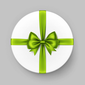 白色的圆圆的礼品盒用绿色石灰缎蝴蝶结缎带