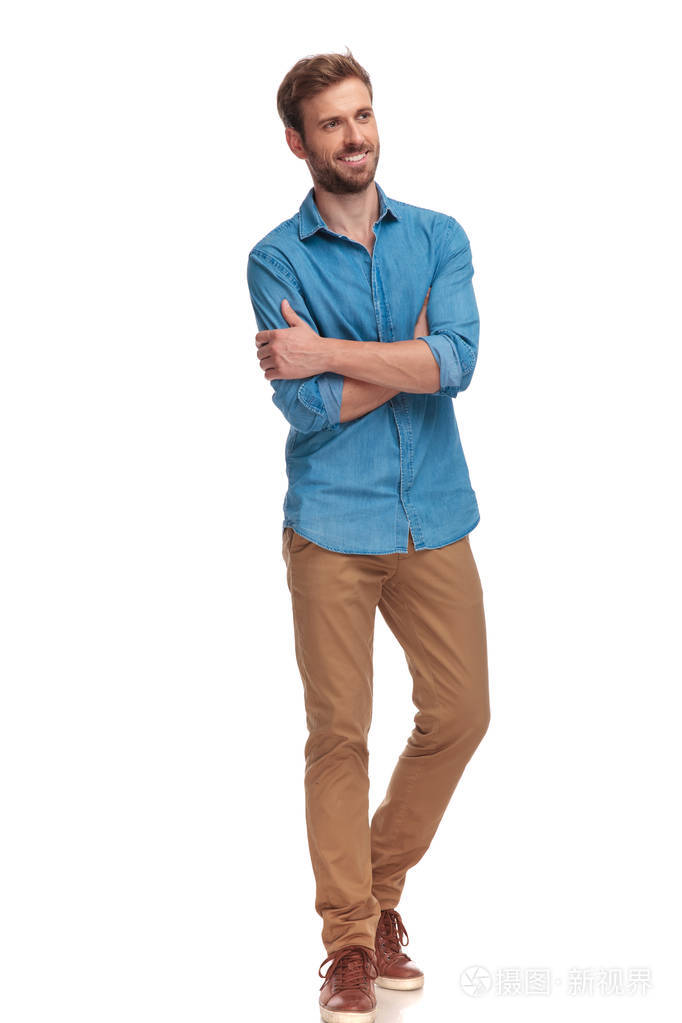 在白色背景下的手交叉的快乐休闲男子的侧面视图