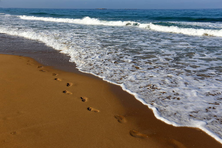 在以色列北部地中海沿岸的沙子上的脚印