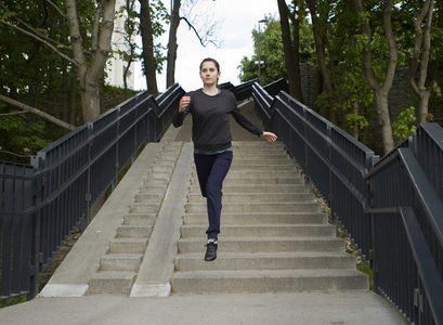 年轻的运动型女人跳台阶上图片