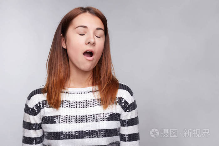 头像年轻无聊的白种女人, 打哈欠孤立在光的背景.