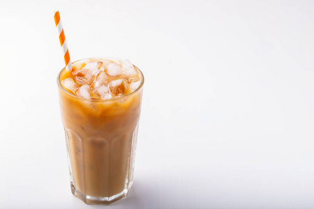 冰咖啡在一个高的玻璃与奶油倒在和咖啡豆。白色背景的冷的夏天饮料以拷贝空间