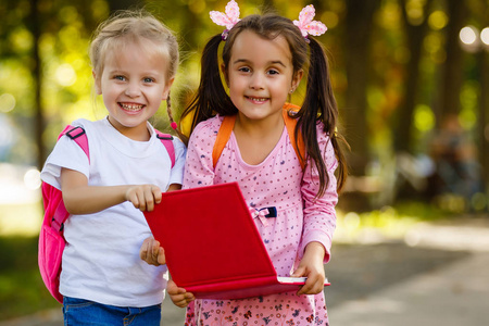 两个美丽的小女孩读粉红色的书照片