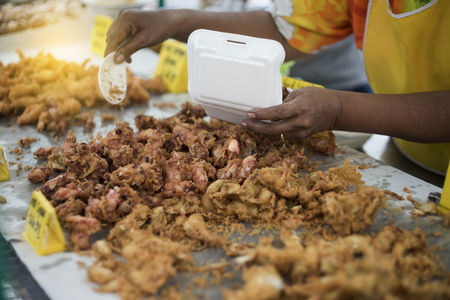 女人手有钢包小鱿鱼在泰国市场风格的一张黄牌的这个食物和价格，选择性的焦点，已过滤的图像，光效果的名称添加一个煎蛋