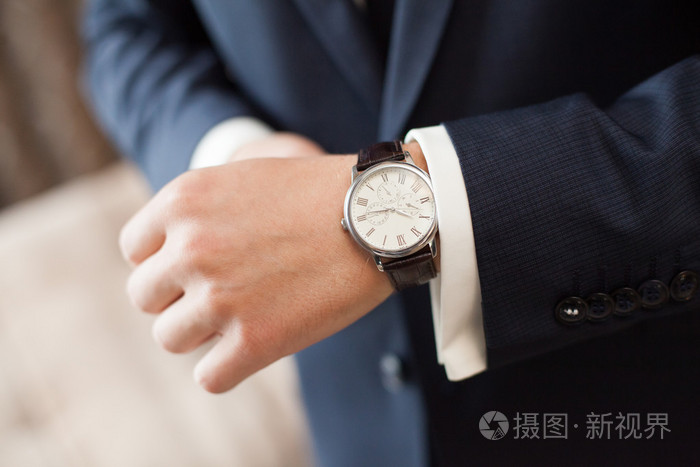 在深色西装新郎戴上手表,特写