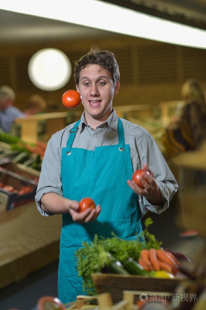 西红柿在超市商店玩弄的杂货店售货员