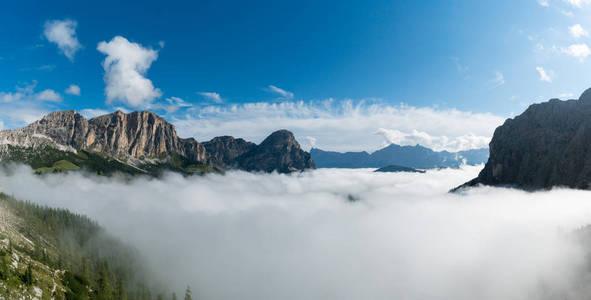 全景山风景在瓦尔加迪纳在意大利白云岩以山峰顶和厚实的云彩盖子在谷在蓝色天空之下在秋天末期