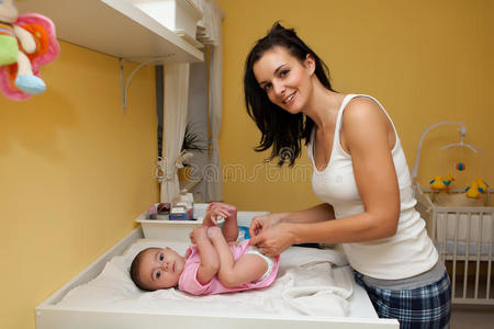 一位母亲给她的宝贝女儿换尿布。