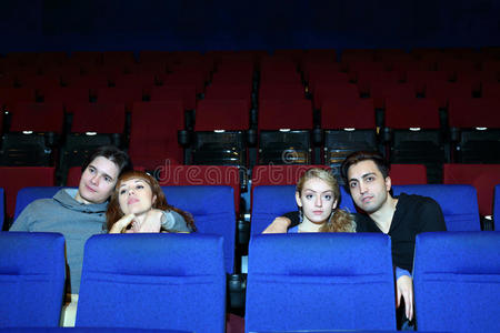 四个年轻人在电影院看电影。