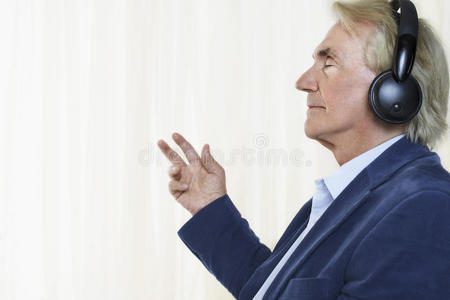 高级商人用耳机欣赏音乐