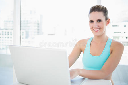 用笔记本电脑穿运动装的快乐女人