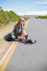 坐在路边沉思的金发女人图片
