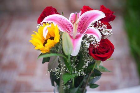 花瓶里有一束向日葵,百合和玫瑰照片