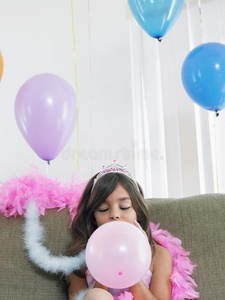 沙发上吹气球的女孩图片