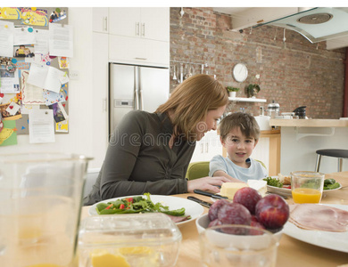 儿子和母亲在厨房的餐桌上吃饭图片